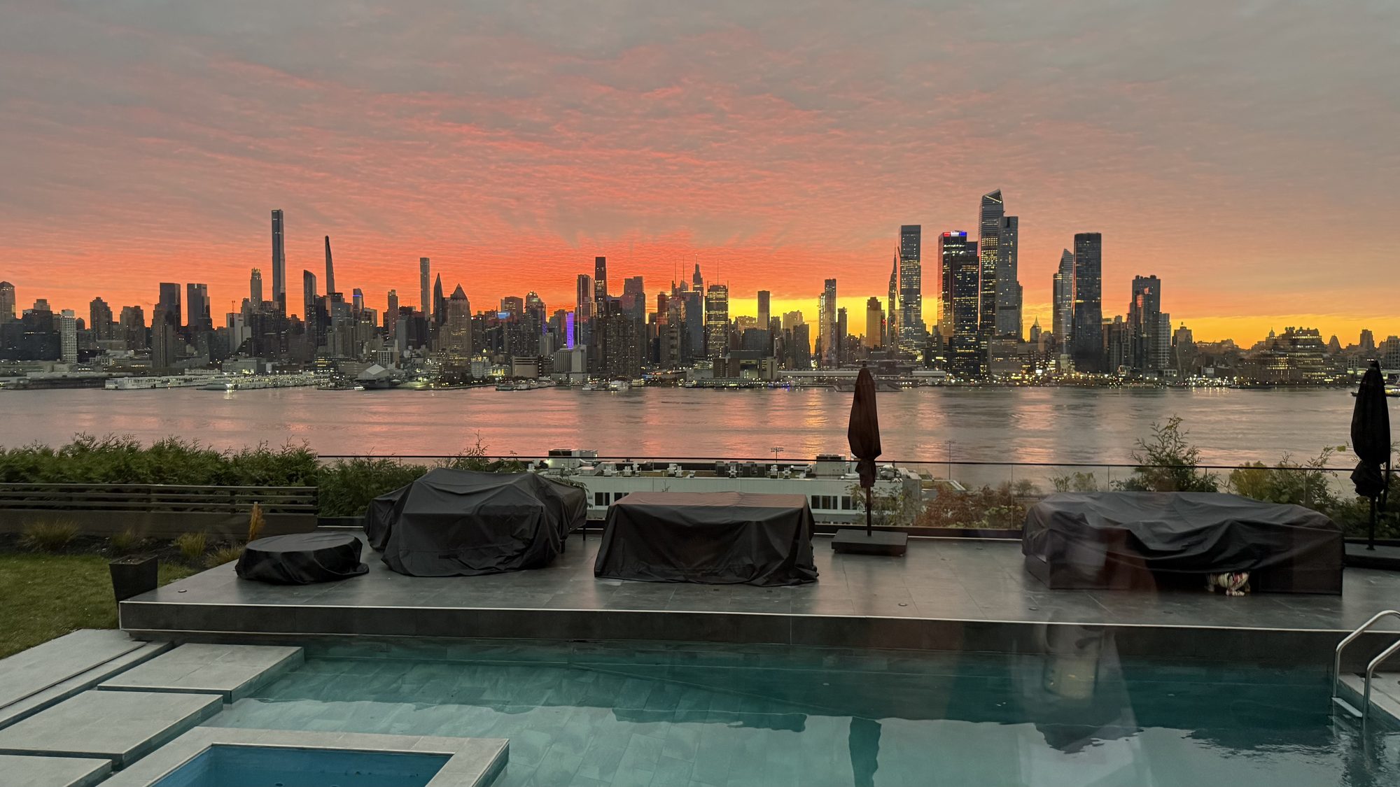 Pool and terrace with skyline at sunset